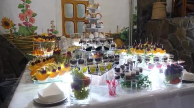 Meyveler, tatlılar ve kekler ile şenlikli tatlı masa. Tatlı bir masanın ahenkli servisi..