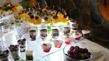 Meyveler, tatlılar ve kekler ile şenlikli tatlı masa. Tatlı bir masanın ahenkli servisi. Büfe masası..