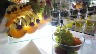 Meyveler, tatlılar ve kekler ile şenlikli tatlı masa. Tatlı bir masanın ahenkli servisi. Büfe masası..