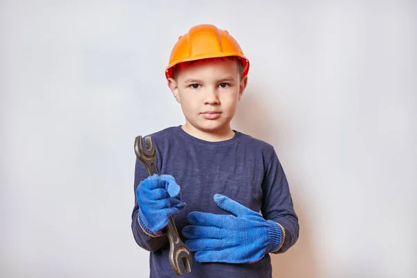 Handsome little boy holding a wrench. Equipment maintenance and repair.