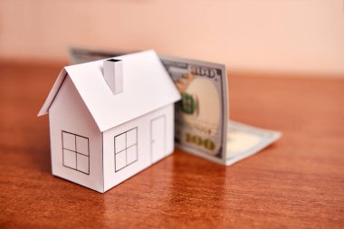 Masadaki ev ve dolarların maketini yap. Gayrimenkul ve emlak piyasası kavramı.