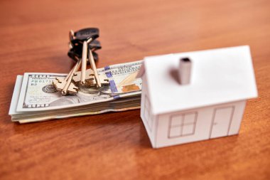 Mock up of housing and dollar bills and key on the table. The concept of buying real estate, real estate market.