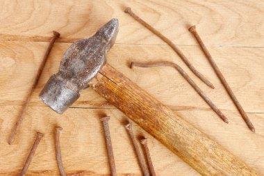 Kahverengi ahşap arka planda çekiç ve çivi 