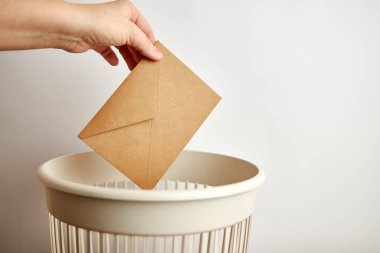 Birisi zarfı çöp kutusuna atıyor. 