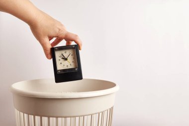 Birisi saati çöp kutusuna atıyor. 