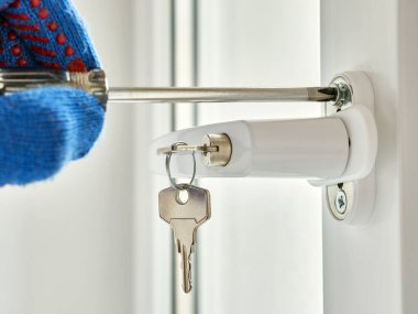 An employee installs a child-safe window handle.