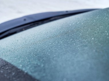Frozen, icy car windshield. Use of the car in winter and during adverse weather conditions. Shooting from a car.
