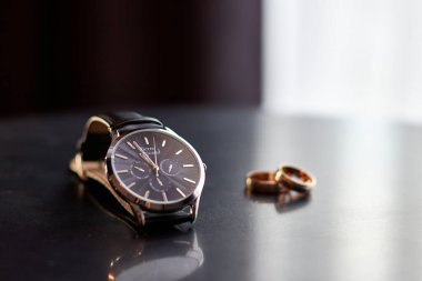 Altın yüzükler ve ahşap bir masaya göz kulak olun.