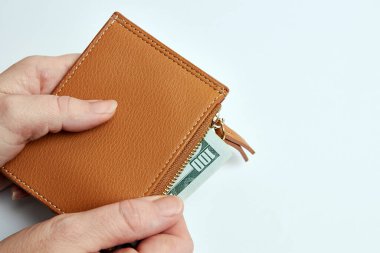 A man looks at a wallet with cash dollars. Wealth and finance.