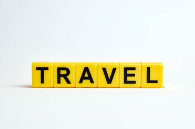 travel text  made from  yellow plastic blocks on a white background