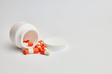 Beyaz arka planda haplar ve şişe.