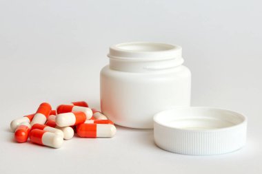 Beyaz arka planda haplar ve şişe.