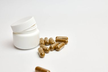 Beyaz arka planda haplar ve şişe.