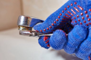 İşçi tuvaletteki musluğu tamir ediyor. 