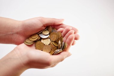 Beyaz arka planda bir yığın bozuk para tutan eller