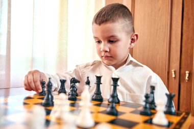 boy playing chess game in room 