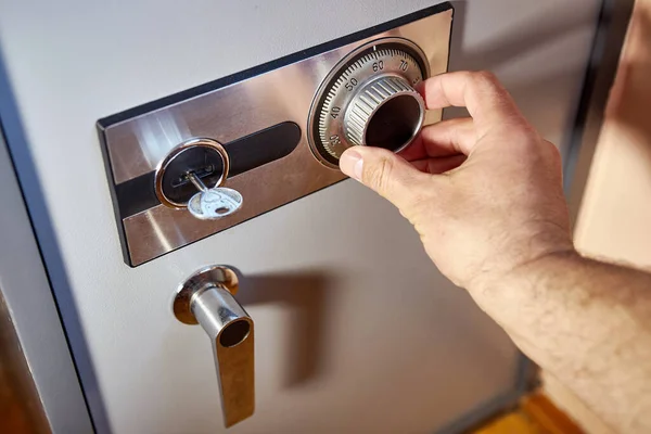 close-up of a hand opening safe