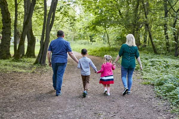 Çocuklu bir aile parkta yürüyor.