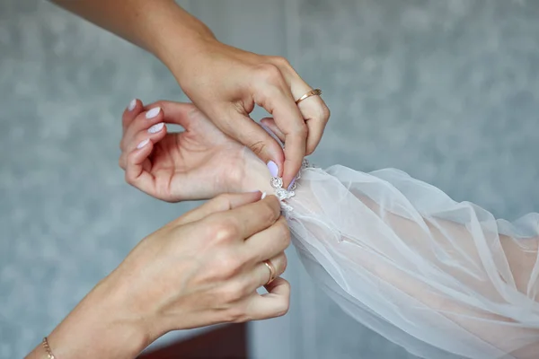 bride hand  in wedding dress. woman helping bride