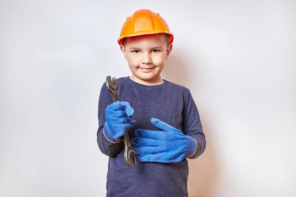 Handsome little boy holding a wrench.