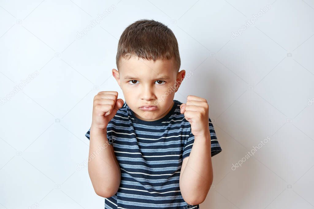 Little boy in a boxing rack with a stern expression.