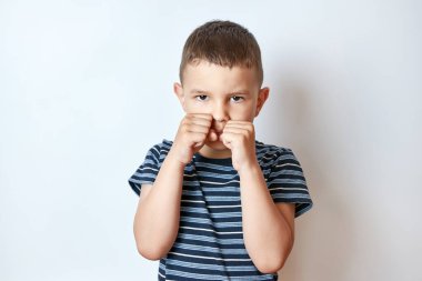 Yüzünde sert bir ifadeyle boks sahasında küçük bir çocuk..