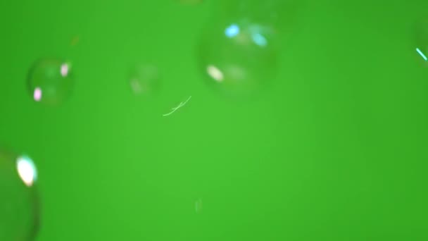 不同方向不同尺寸的肥皂泡在绿色背景下飞舞 — 图库视频影像