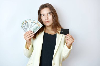 Elinde nakit para ve kredi kartı tutan güzel bir kız. Nakit veya nakit olmayan ödeme kavramı.
