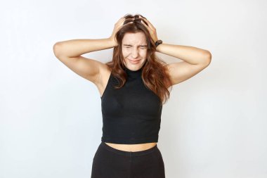 Güzel kız iki elini de başının arkasında tutuyor..