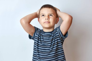 Yakışıklı bir çocuk ellerini başının arkasında tutuyor..