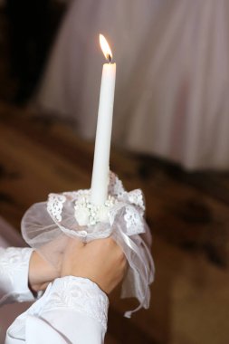 Ayin sırasında kilisede bir dekoratif mum tutulur..