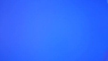 Farklı boyutlarda sabun köpükleri mavi arka planda uçar..