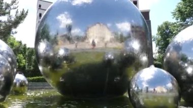 Farklı çaplarda metal toplar şeklinde çeşme. Modern bir şehrin kentsel görüşü.