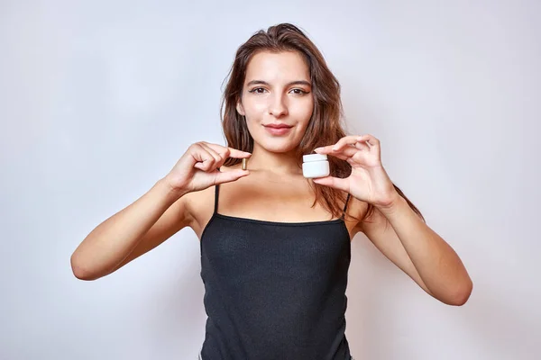 The girl holds a capsule and its packaging in her hands. Medical means for weight loss.