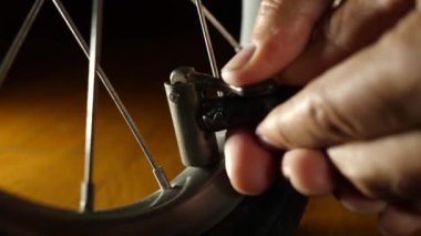 The bicycle wheel is inflated with a hand pump. Service and maintenance of bicycles.