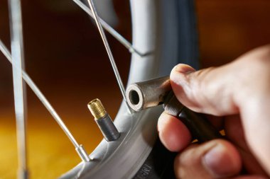 Bisiklet tekerleği bir el pompasıyla şişirilir. Bisikletlerin servisi ve bakımı.