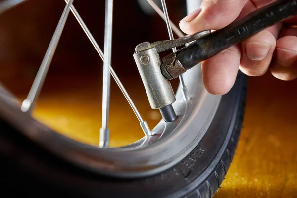 The bicycle wheel is inflated with a hand pump. Service and maintenance of bicycles.