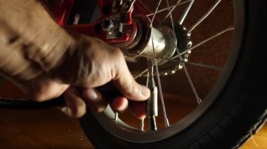The bicycle wheel is inflated with a hand pump. Service and maintenance of bicycles.