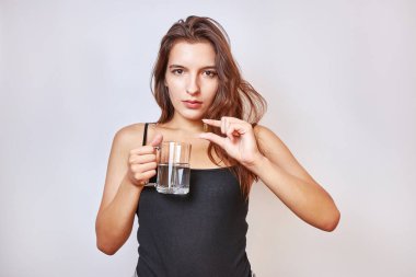 Kız elinde bir kapsül ve ambalajı tutuyor. Kilo vermek için tıbbi araçlar.