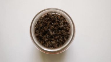 Bee excrement (the bodies of dead honey bees) is collected and poured into a jar for medicinal use. Use of beekeeping products for medicinal purposes.