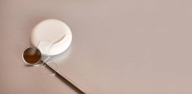 Gri bir arka planda diş ipi ve diş aynası. Diş bakımı.