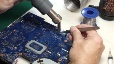 When repairing the motherboard, the chip is unsoldered. Repair and maintenance of computers.