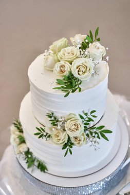 A beautiful weA beautiful wedding cake decorated with fresh roses. Wedding celebration.dding cake decorated with fresh roses. Wedding celebration.