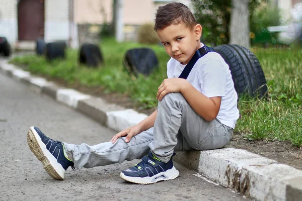 Handsome little boy sitting and posing for the camera. Carefree childhood.