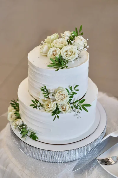 A beautiful weA beautiful wedding cake decorated with fresh roses. Wedding celebration.dding cake decorated with fresh roses. Wedding celebration.