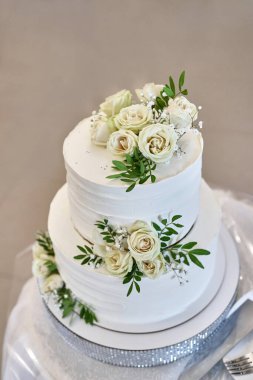 A beautiful weA beautiful wedding cake decorated with fresh roses. Wedding celebration.dding cake decorated with fresh roses. Wedding celebration.