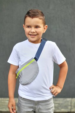 A handsome little boy is posing for the camera, smiling. Carefree childhood.
