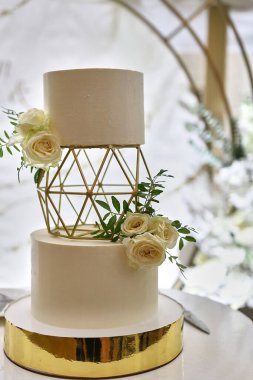 Beyaz güllerle süslenmiş güzel bir düğün pastası. Düğün kutlaması.