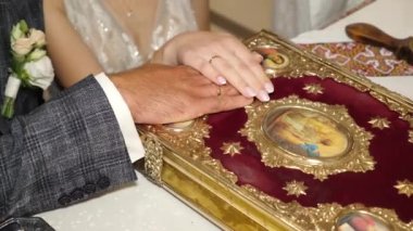 During a church wedding, the bride and groom make vows to each other and rely on the Gospel. Wedding ceremony.