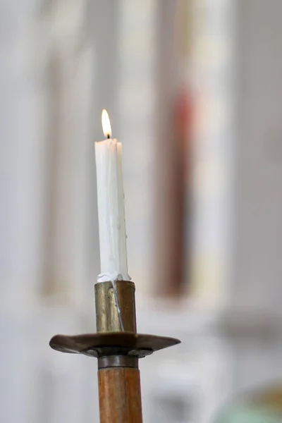 A candle burns in the church during the service.